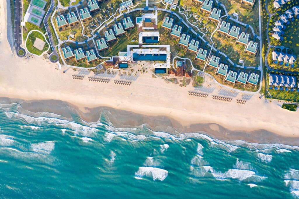 Aerial view of modern seaside properties lining Bai Dai coast, illustrating the scale of beach resorts in Cam Ranh.
