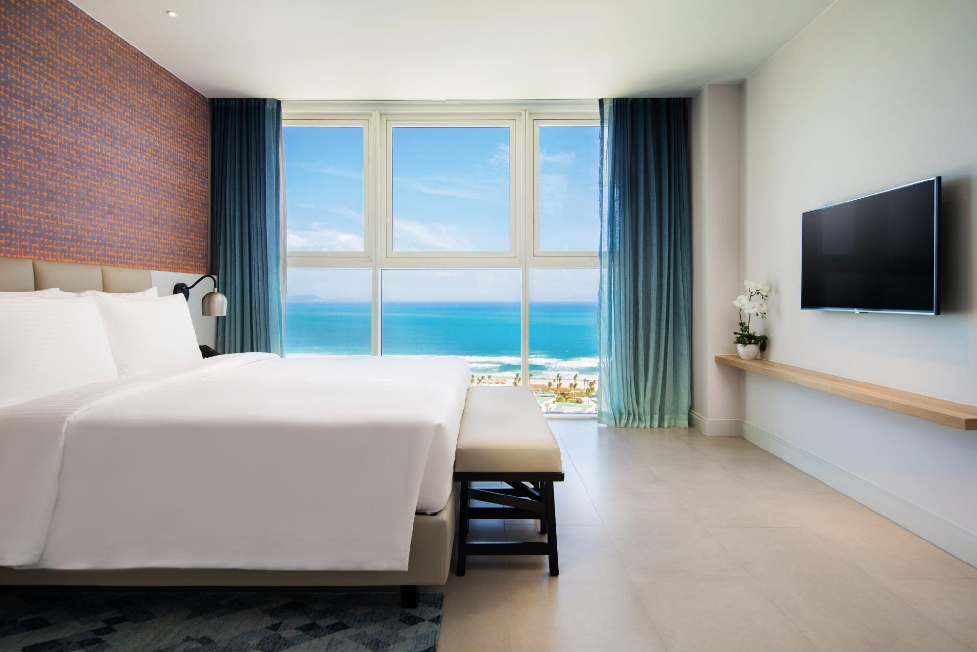 Spacious ocean-view room with private balcony overlooking the coastline, representing the comfort of beach resorts in Cam Ranh.
