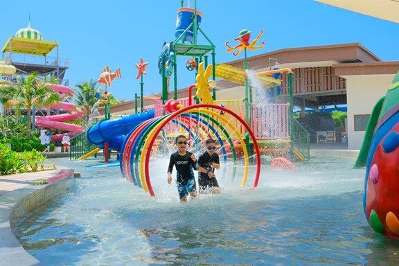 Families relaxing on Bai Dai Beach with calm waters near family resorts in Cam Ranh.