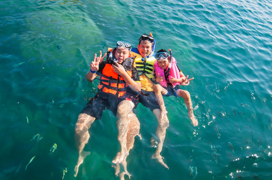 Guests relaxing at a beachfront resort pool overlooking the ocean, illustrating leisure things to do in Cam Ranh.